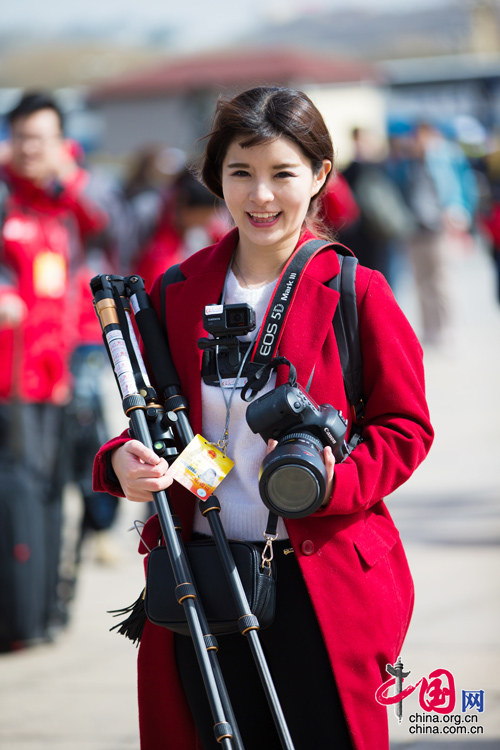 2016年兩會，人民大會大堂前，一位笑容燦爛的紅衣女記者正步入大會堂。中國網(wǎng) 鄭亮 攝