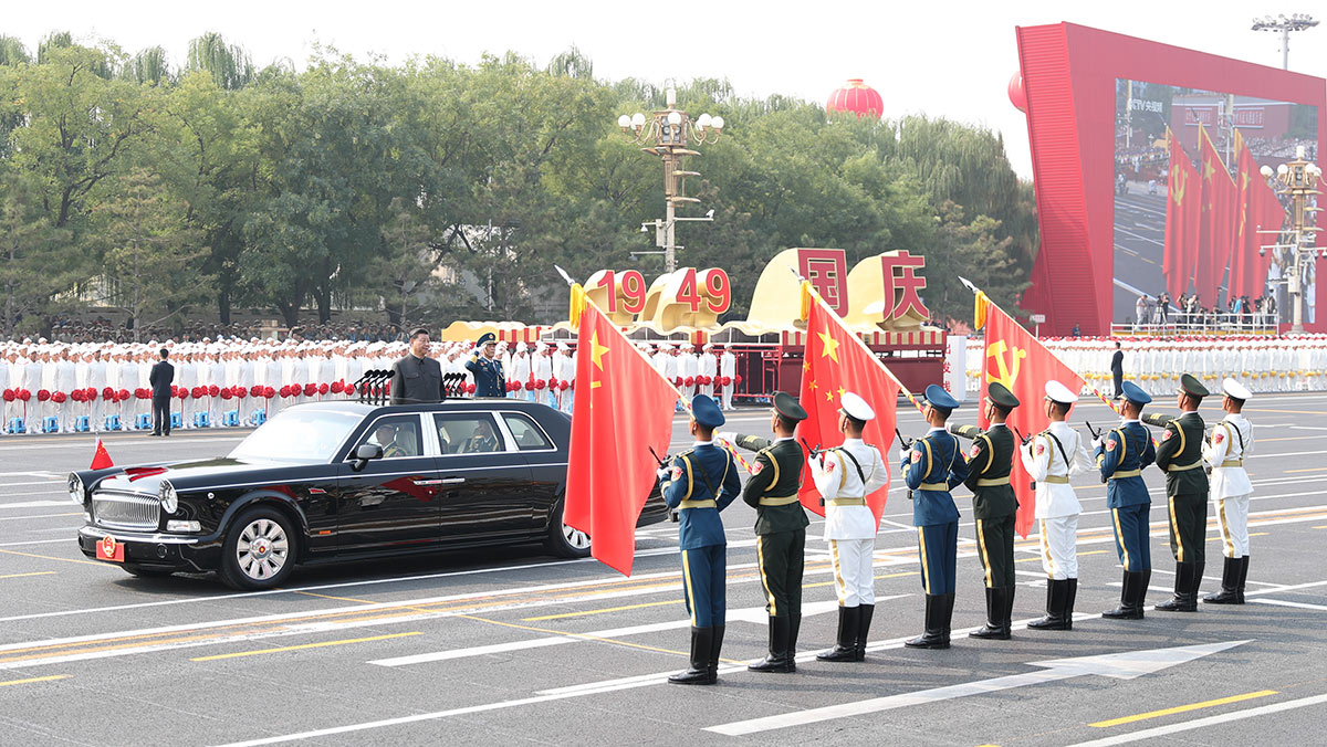 習(xí)近平驅(qū)車行進(jìn)至黨旗、國旗、軍旗前，向旗幟行注目禮